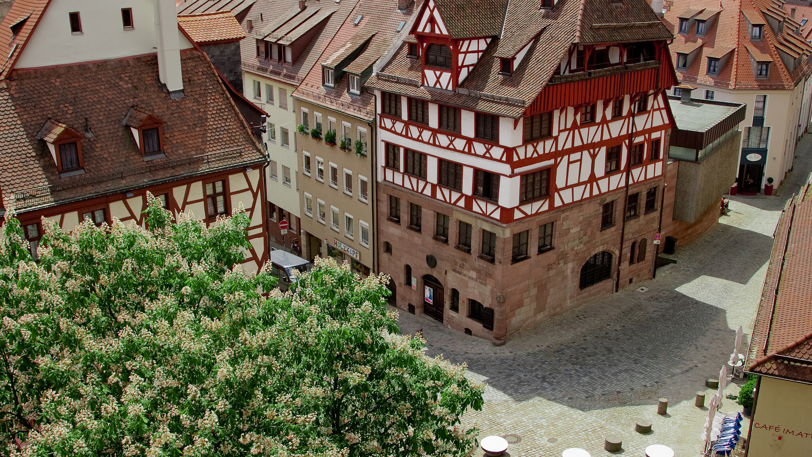 Blick von oben auf das markante Albrecht-Dürer-Haus in der Nürnberger Altstadt, ein mehrstöckiges Fachwerkhaus mit Sandsteinerdgeschoss und hohem Walmdach.