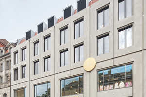 Modernes Wöhrl‑Gebäude am Jakobsmarkt mit klarer Rasterfassade, großen Schaufenstern und goldfarbenem Eingangsschild.